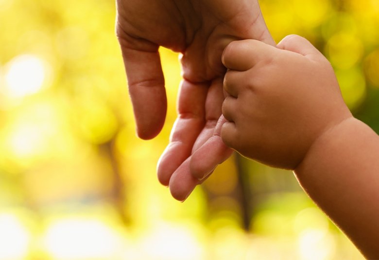 parent qui tient la main de son enfant